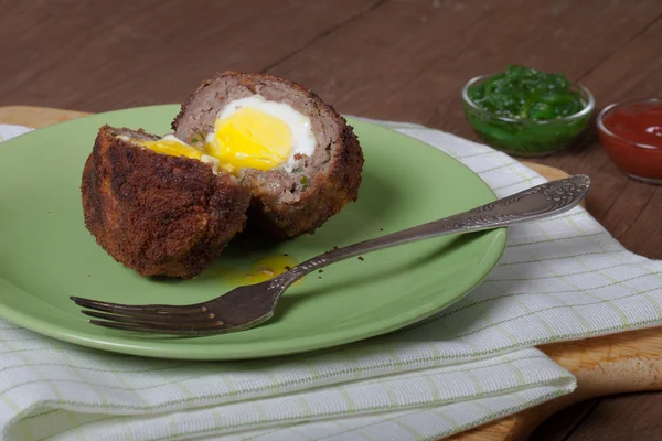 Жареная котлета с яйцом внутри подается на тарелке. Селективный фокус — стоковое фото