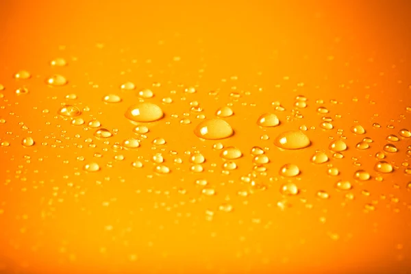 Drops of water on a color background. Orange. Shallow depth of f Royalty Free Stock Photos