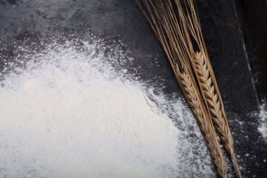 Buğday kulak ve siyah arka plan üzerine serpin un