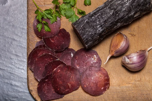 Salsicha de cavalo cortada, ervas e especiarias na tábua de corte — Fotografia de Stock