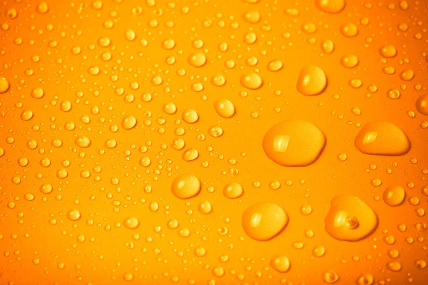 Gotas de água em um fundo a cores. Laranja. Profundidade rasa de f — Fotografia de Stock