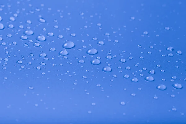 Wassertropfen auf einem farbigen Hintergrund. blau. Flache Tiefe des fie — Stockfoto