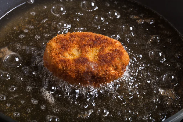 Cutlet fried in oil in a frying pan. Selective focus — Stock Photo, Image