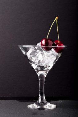 Bir martini cam siyah arka plan üzerine kiraz çilek