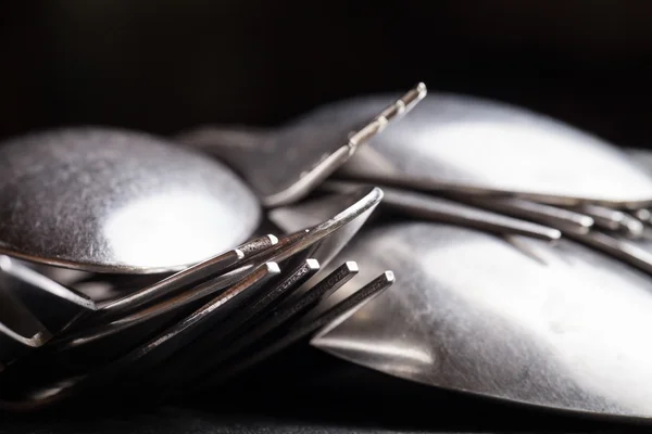Lot of metal cutlery on a black background. Selective focus. Sha — Stock Photo, Image