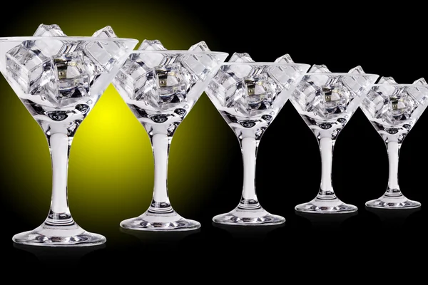 Eiswürfel in Martini-Gläsern auf farbigem Hintergrund — Stockfoto