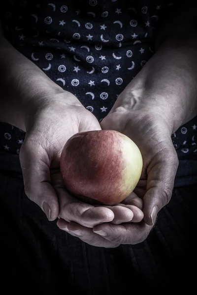 Äpple i händerna på en äldre kvinna. Tonas — Stockfoto