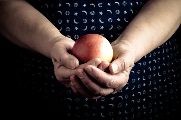 Äpple i händerna på en äldre kvinna. Tonas — Stockfoto