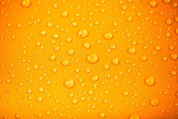 Gotas de água em um fundo a cores. Laranja. Profundidade rasa de f — Fotografia de Stock