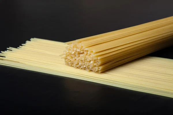 Паста-спагетти на черном фоне. Выборочный фокус. Космос — стоковое фото