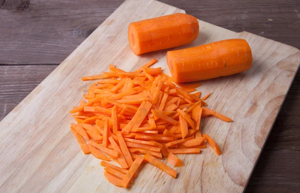 Zanahorias en rodajas en una tabla de cortar de madera —  Fotos de Stock