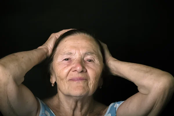 Портрет пожилой женщины. Корректирует прическу. Toned — стоковое фото