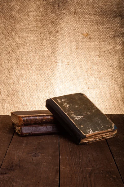 Stapelen van oude boeken over de oude houten tafel — Stockfoto