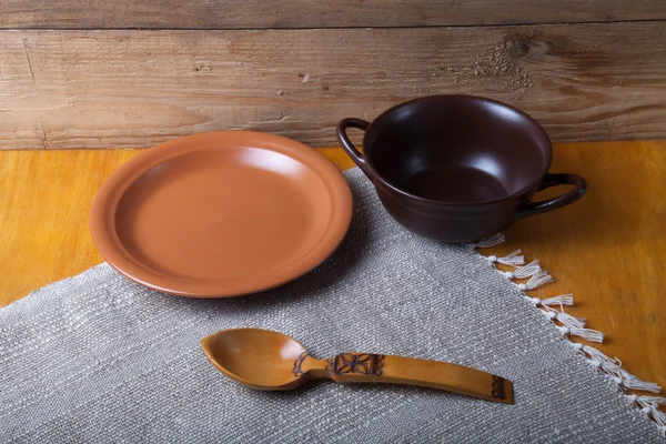 Rustikales Stillleben. Tontopf, Löffel und Teller auf Leinenserviette. wo — Stockfoto