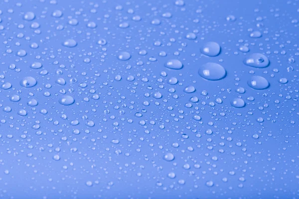 Csepp víz egy színű háttér. Kék. Sekély mélység-ból mező — Stock Fotó