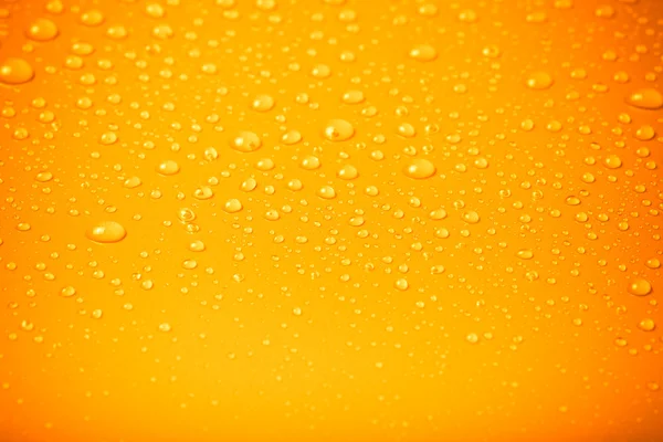 Gotas de agua sobre un fondo de color. Naranja. Profundidad superficial de f — Foto de Stock