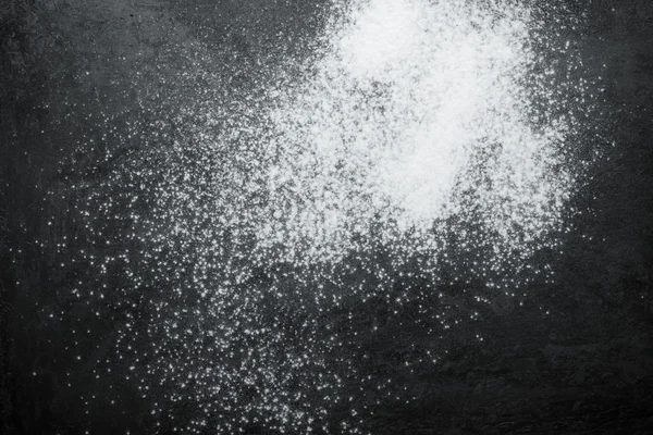 Flour spilling on black metal background. Toned — Stock Photo, Image