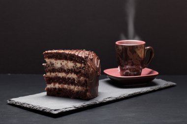 Parça çikolatalı kek ve kahve blac kayrak plaka üzerinde