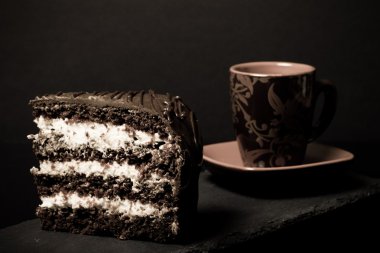 Parça çikolatalı kek ve kahve blac kayrak plaka üzerinde