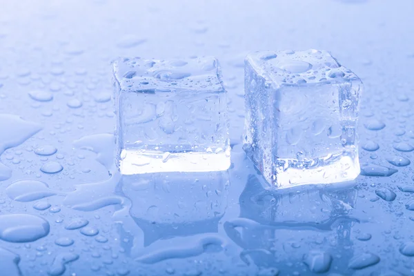 Cubos de hielo en una mesa húmeda. Enfoque selectivo. Tonificado —  Fotos de Stock