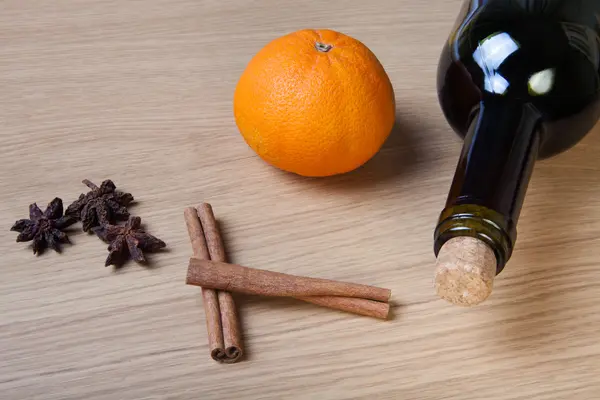 Fresh orange, bottle of vine and spices on a light wooden table — Stock Photo, Image