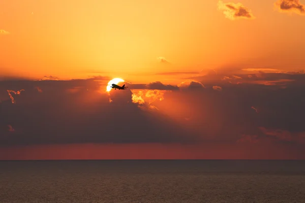 Black silhouette of an airplane on a background of a beautiful s — Stock Photo, Image