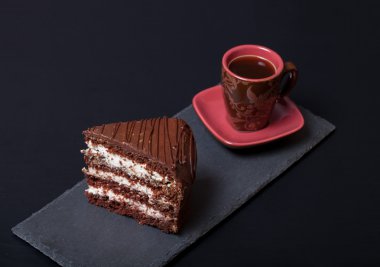 Parça çikolatalı kek ve kahve blac kayrak plaka üzerinde