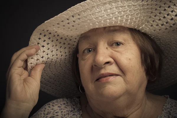 Portrait of elderly woman with a hat. Question. Toned — Stock Photo, Image