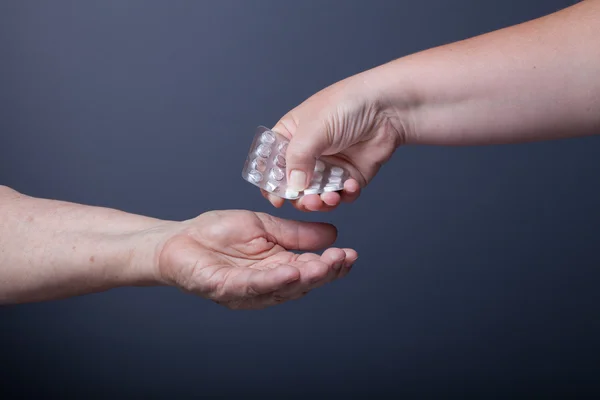 Handen van ouderen en jonge vrouwen op zwarte achtergrond — Stockfoto