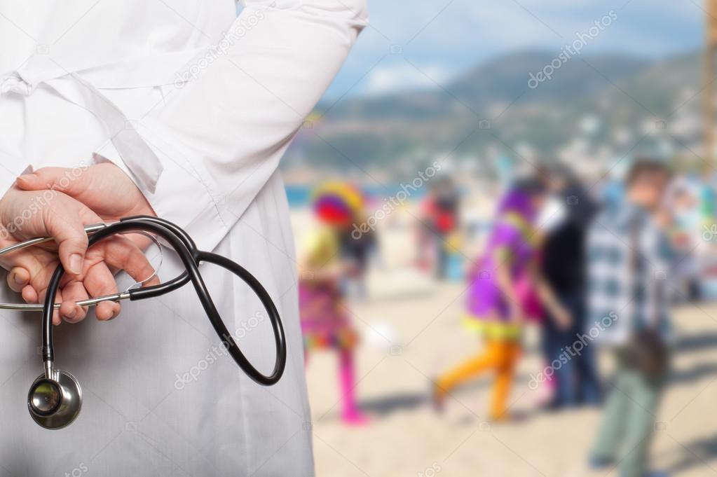 The doctor put his hands with stethoscope behind his back on a b