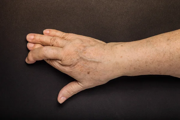 Handen van oudere vrouw op zwarte achtergrond. Toned — Stockfoto
