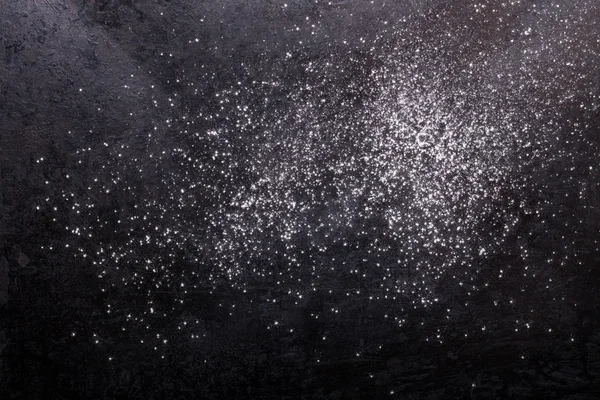 Flour spilling on black metal background — Stock Photo, Image