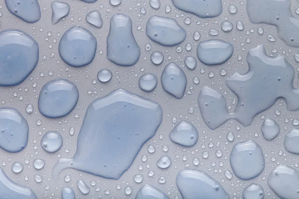 Druppels van het water op een achtergrond in kleur. grijs. ondiepe scherptediepte fie — Stockfoto