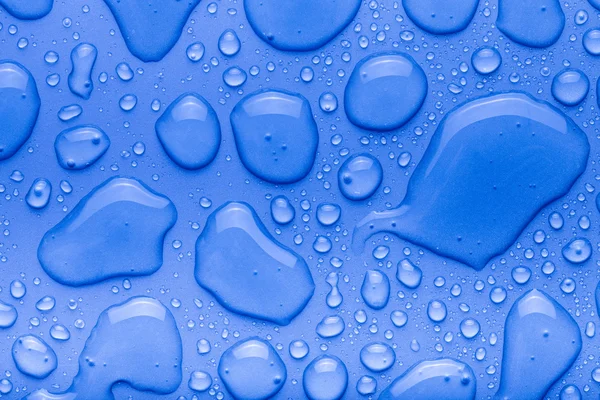 Gocce d'acqua su uno sfondo a colori. Blu. Profondità superficiale di fie — Foto Stock