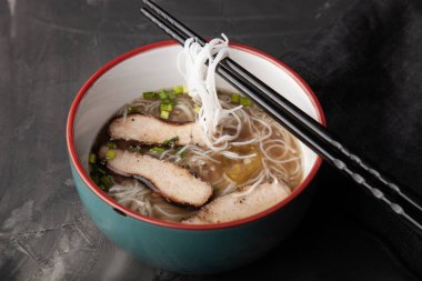 Bir kase pirinç eriştesi, et ve sebzeli kompozisyon..