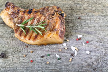 Büyük bir parça taze domuz eti, arka plan için eski ahşap masadaki ızgara tepsisinde hazırlanmış bir kemik üzerinde..