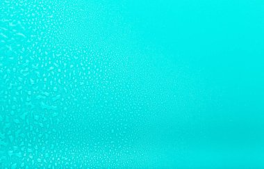 Renkli arka planda bir damla su. Seçici odaklanma. Mavi.