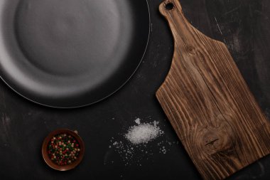 Kil plakalı kompozisyon ve karanlık bir masa üzerinde baharatlar. Metin için boşluk.