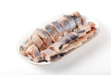 Hafif arka planda oval tabakta tuzlanmış ringa balığı. Salamura edilmiş balık. Geleneksel Rus mezeleri.