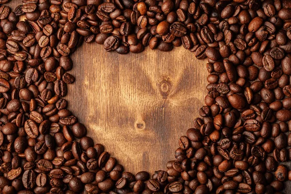 壁紙や装飾のための古い暗い木製の背景にローストコーヒー豆 — ストック写真