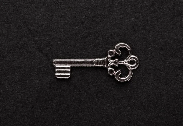Decorative metal key on the empty black background.