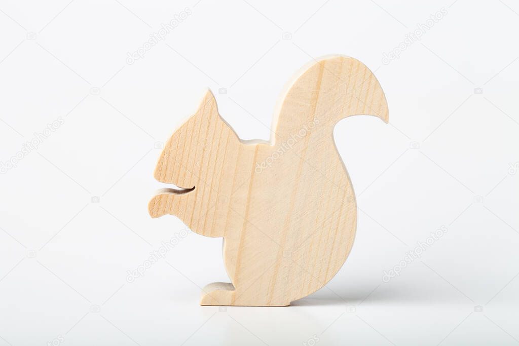 Squirrel figurine carved from solid pine by hand jigsaw. On a white background .