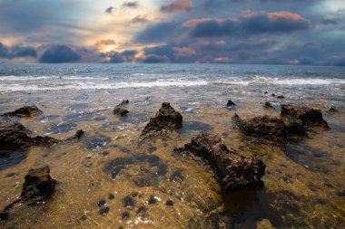 azalttığın deniz kıyı şeridi ve gün batımında su çukurları ile taş
