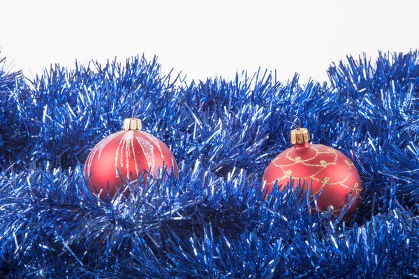 Red Christmas balls on the background of blue tinsel — Stock Photo, Image