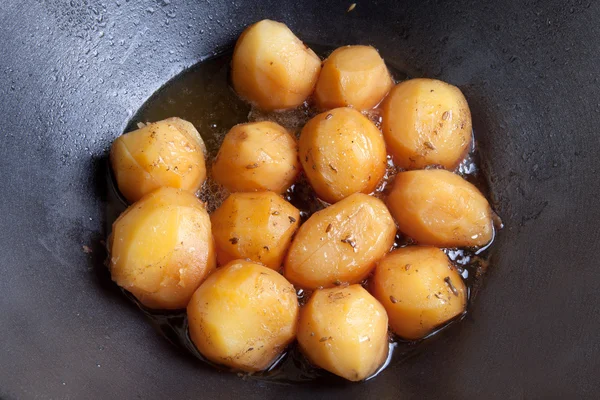 Batatas fritas inteiras em óleo em um caldeirão — Fotografia de Stock