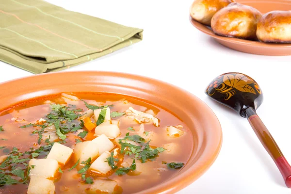 Тарелка овощного супа, деревянная ложка и торты на легком пакете — стоковое фото