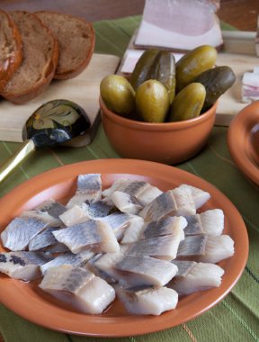 ringa balığı, ekmek, turşu ve pastırma yeşil peçeteye plakalı