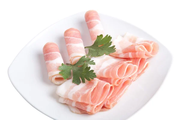 Bacon slices with parsley on a plate isolated on white backgroun — Stock Photo, Image