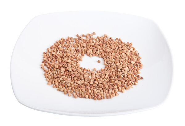 plate with buckwheat groats isolated on white background