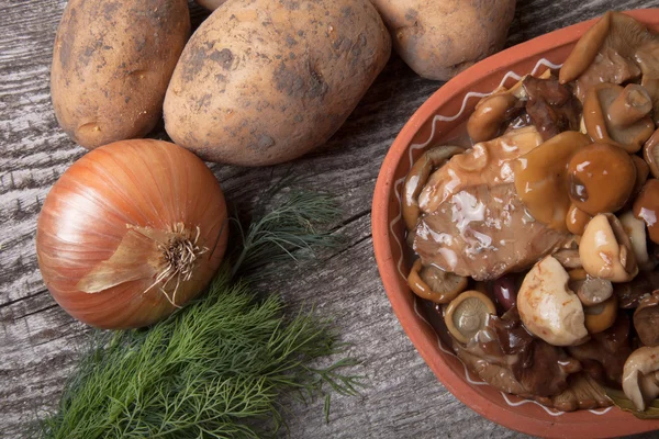 Salta mashrooms, potatis, lök, dill och spannmål i en skål på en ol — Stockfoto